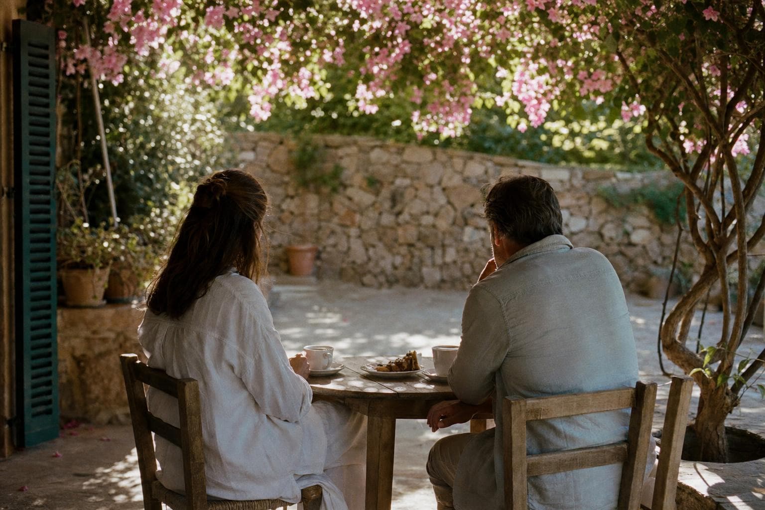 Zwei Menschen im Gespräch mit Kaffee auf einer Finca-Terrasse